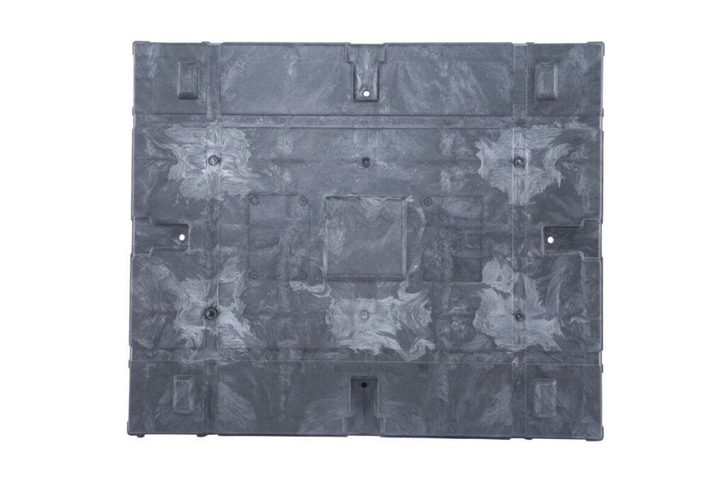 A black plastic sheet with holes, resembling a plastic pallet.